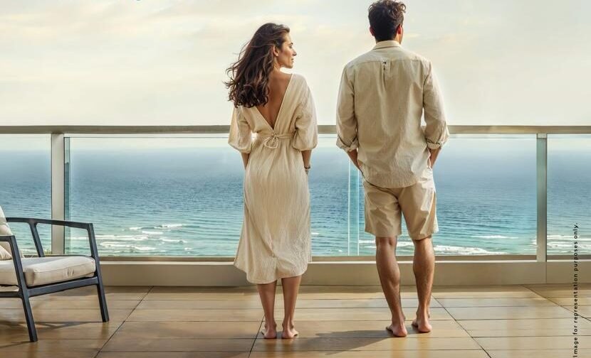 Luxury sea-view balcony at Kolte Patil Serenova Andheri West – a couple enjoying the panoramic Versova beach view from Four Bungalows.